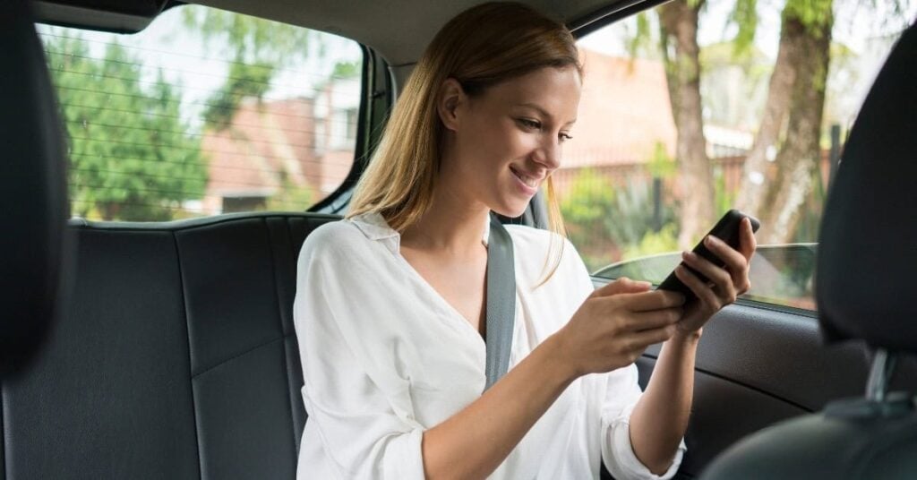 Person sitzt im Auto und bucht eine Fahrt mit Grab