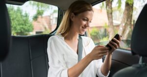 Person sitzt im Auto und bucht eine Fahrt mit Grab