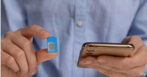 Person setzt eine indonesische SIM-Karte in ein Smartphone ein – Anleitung für Touristen, wie man eine SIM-Karte in Indonesien aktiviert.