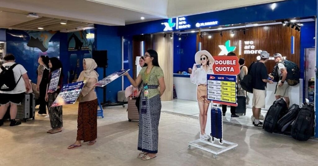 Touristen kaufen eine SIM-Karte am Flughafen Bali – offizieller Verkaufsschalter für indonesische Prepaid-Karten.